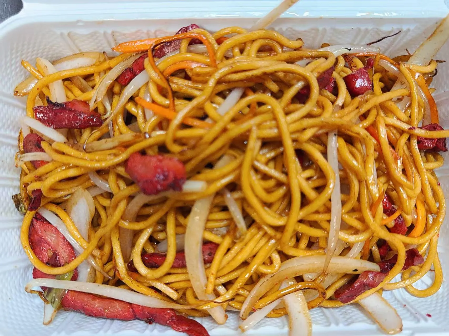 Barbecue pork lo mein mixed with carrot, onion strips in white plastic container at Silk Road Bistro, a Chinese Restaurant in Martiborough